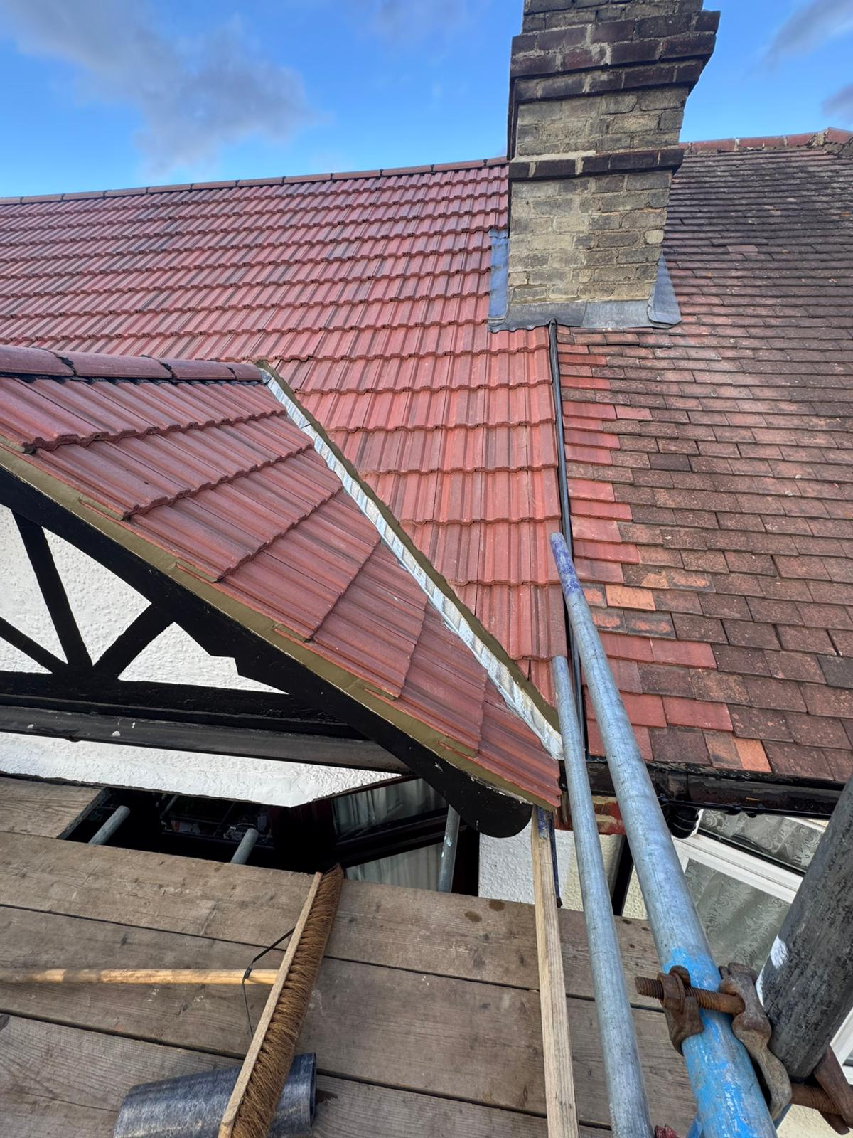 Roof and chimney repair in progress with scaffolding